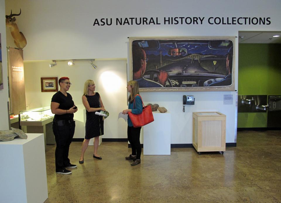 Three people chatting in a museum setting