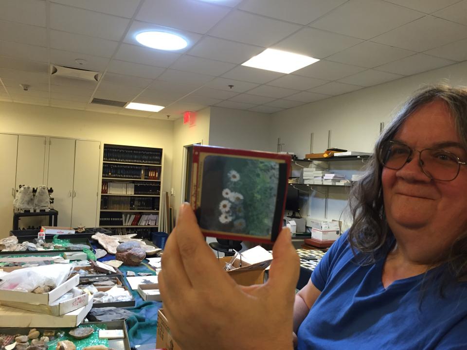 Woman in blue shirt holding an object