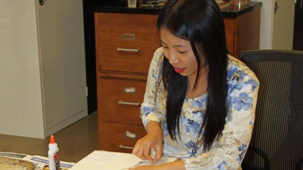 Young woman wearing flower shirt mounting grasses