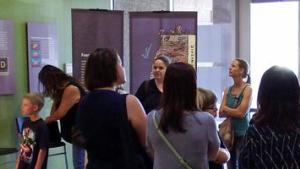 Group of adults and kids indoors in a museum exhibit setting